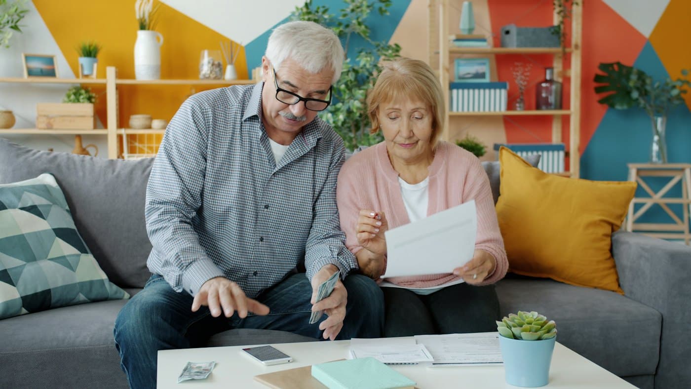 Un couple de retraités consulte ses documents de prévoyance